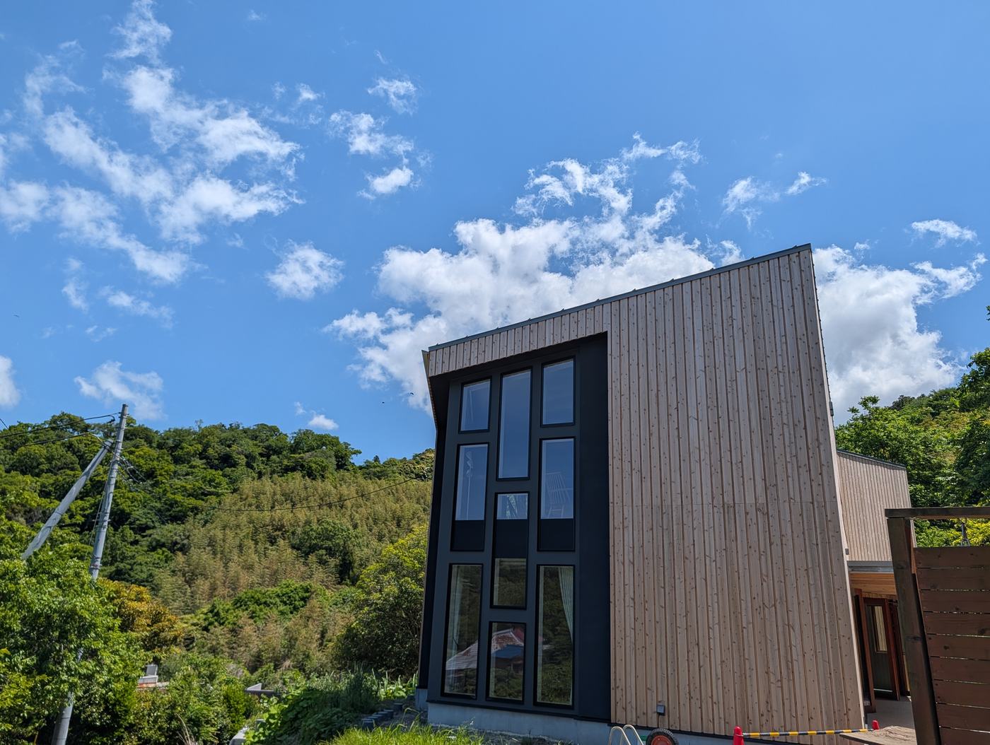 緑の斜面を背にした建物とガラス面